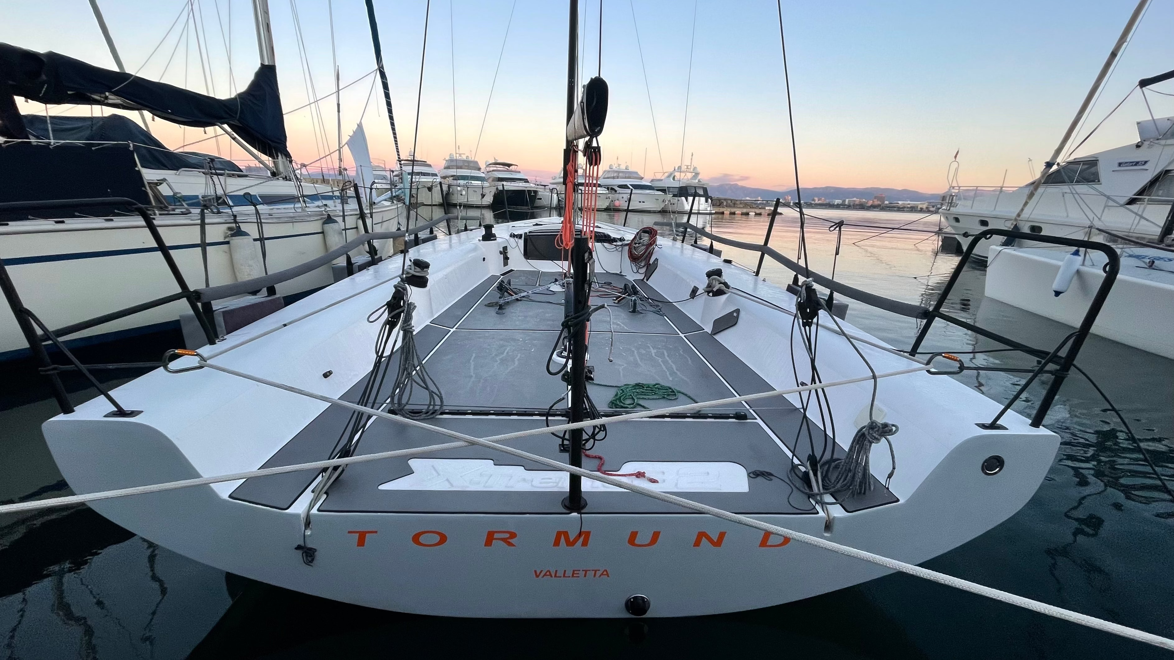 Sailboat named 'Tormund' on the water with a sunset or sunrise in the background. Winchhandle bags, Jetboils, Sheetreelers Reelers